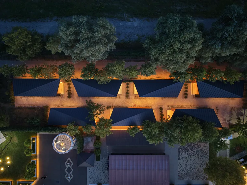 Acoperișurile caselor de cazare, văzute de sus, cu terasele luminate între ele